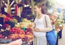 Gestante feliz e ecolhendo alimentos na feirinha