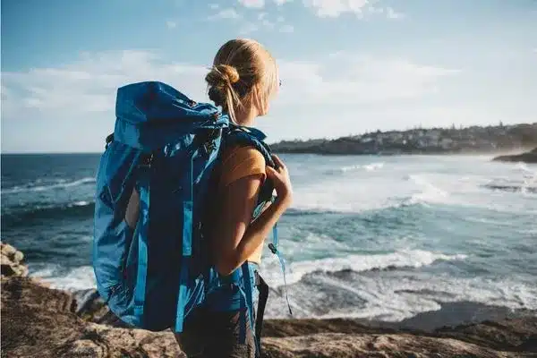 Mulher feliz com mochila nas costas em viagem