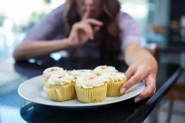 Mulher com transtorno alimentar comendo escondido